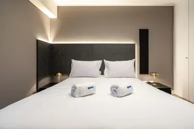 a bedroom with a large white bed with two towels on it at Artline by Geko in Lima