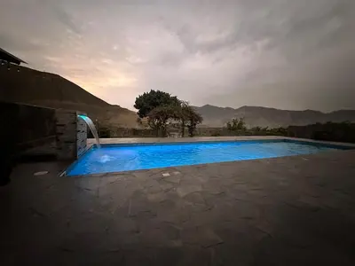 a swimming pool with blue water on a patio at Casa campo en Cieneguilla 2,040m2 in Pachacamac