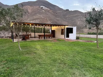 a building with a bench in a field of grass at Casa campo en Cieneguilla 2,040m2 in Pachacamac