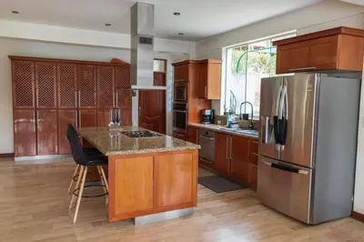 a kitchen with wooden cabinets and a stainless steel refrigerator at Casa campo en Cieneguilla 2,040m2 in Pachacamac