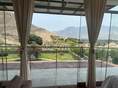a room with a large window with a view of a mountain at Casa campo en Cieneguilla 2,040m2 in Pachacamac