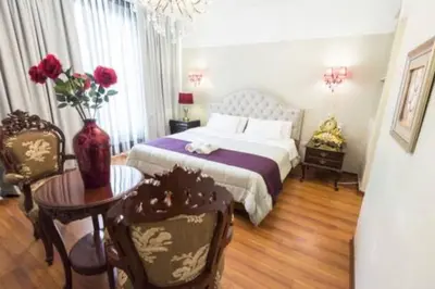 a bedroom with a bed and a table and a vase with roses at INTI KILLA Hostel in Lima