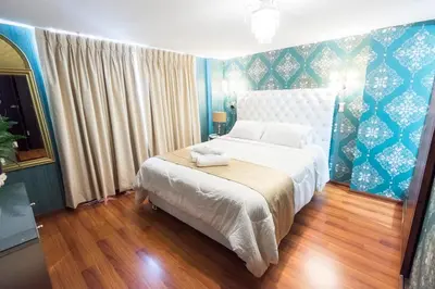 a bedroom with a large bed with a blue wall at INTI KILLA Hostel in Lima