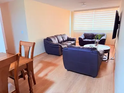 a living room with two couches and a table at Acogedor Departamento en Lima in Lima