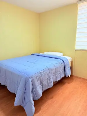 a bedroom with a bed with a blue blanket at Acogedor Departamento en Lima in Lima