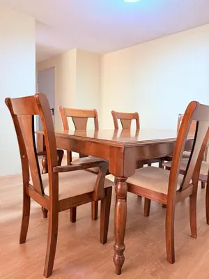 a dining room table with chairs and a wooden table at Acogedor Departamento en Lima in Lima