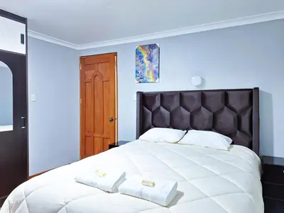 a bedroom with a large bed with two towels on it at Jerusalen Inn-Dep 4 in Cusco