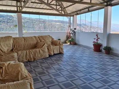 a living room with a couch in a room with windows at Jerusalen Inn-Dep 4 in Cusco
