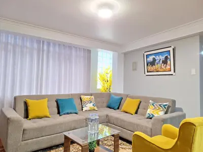 a living room with a couch with yellow and blue pillows at Jerusalen Inn-Dep 2 in Cusco