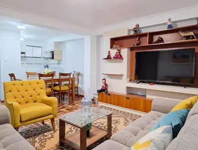 a living room with a tv and a couch and a table at Jerusalen Inn-Dep 2 in Cusco