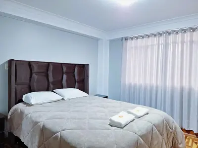 a bedroom with a large bed with two towels on it at Jerusalen Inn-Dep 3 in Cusco