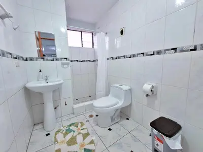 a white bathroom with a toilet and a sink at Jerusalen Inn-Dep 3 in Cusco