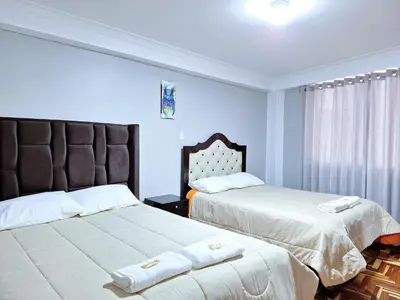 two beds in a bedroom with blue walls at Jerusalen Inn-Dep 3 in Cusco