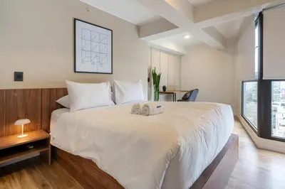 a bedroom with a large white bed and a window at Canaval y Moreyra by Geko in Lima