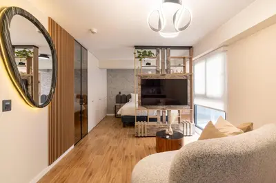 a living room with a couch and a mirror at Canaval y Moreyra by Geko in Lima