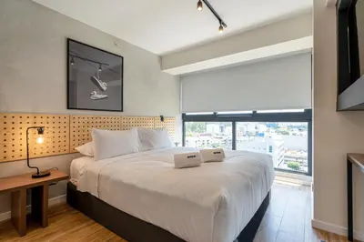a bedroom with a large bed and a window at Canaval y Moreyra by Geko in Lima