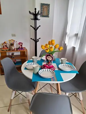 a table with plates and a vase of flowers on it at cusco céntrico in Cusco