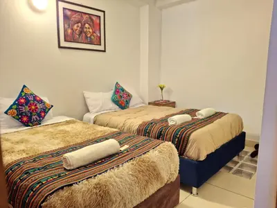 a room with two beds with towels on them at cusco céntrico in Cusco