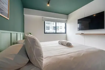 a bedroom with a large white bed with a flat screen tv at Eco 28 by Geko in Lima