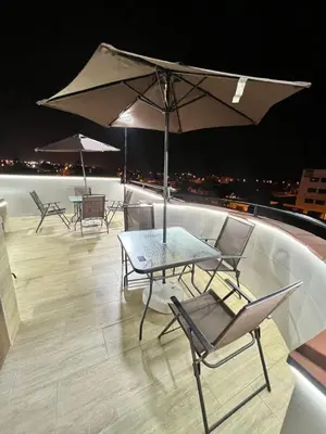 a table and chairs on a roof with an umbrella at Hotel Gboss in Punta Hermosa
