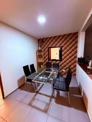 a dining room with a glass table and chairs and a television at Hotel Gboss in Punta Hermosa