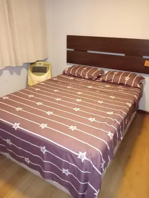 a bedroom with a bed with a purple blanket with stars at Spacious Apartment - Los Olivos in Lima