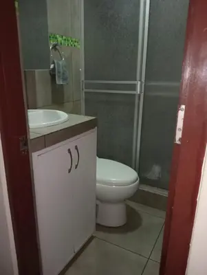 a bathroom with a toilet and a sink and a shower at Spacious Apartment - Los Olivos in Lima