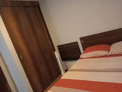a bedroom with a bed and a wooden door at Spacious Apartment - Los Olivos in Lima