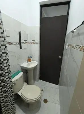 a bathroom with a toilet and a sink and a shower at Mini departamento acogedor en el centro de Huánuco in Huánuco