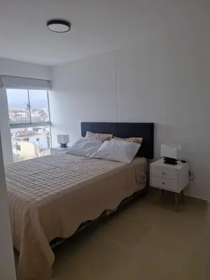 a bedroom with a large bed and a window at Departamento a un paso de playa Pulpos y Arica in Lurín