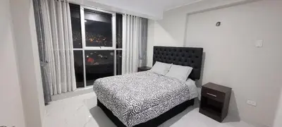 a white bedroom with a bed and a window at La mansión in Cusco