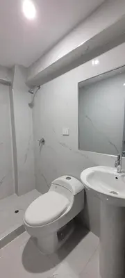 a white bathroom with a toilet and a sink at La mansión in Cusco
