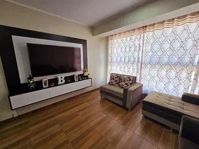 a living room with a flat screen tv and a couch at Depa moderno - Aeropuerto, San Marcos, Católica in Lima