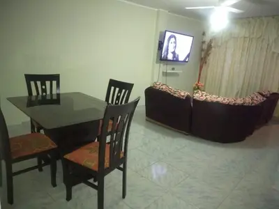 a dining room with a table and chairs and a television at Angelica's House Apartments in Lima
