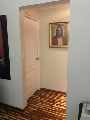 a hallway with a painting of a man on the wall at Cozy Condo in Miraflores in Lima