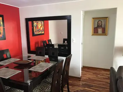 a dining room with red walls and a table and chairs at Cozy Condo in Miraflores in Lima