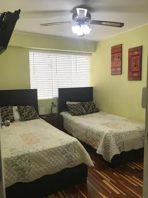 a bedroom with two beds and a ceiling fan at Cozy Condo in Miraflores in Lima