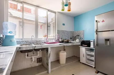a large kitchen with blue walls and a refrigerator at Apartamento en Cuzco in Cusco