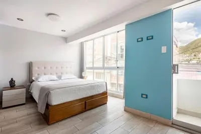 a bedroom with a bed and a large window at Apartamento en Cuzco in Cusco