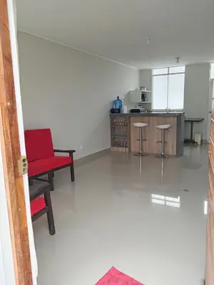 a kitchen with a red chair and a counter at Huacachina house in Ica