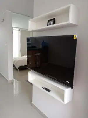 a large flat screen tv on a white entertainment center at Huacachina house in Ica