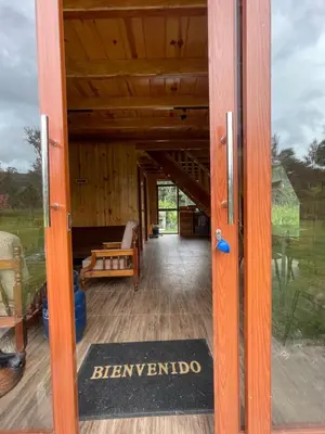 an open door to the porch of a wooden house at Cabaña Alpina Yanesh Haus in Oxapampa