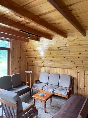 a log cabin with two couches and a table at Cabaña Alpina Yanesh Haus in Oxapampa