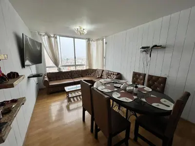 a living room with a table and a couch at DEPARTAMENTO FRENTE ARENa 1 in Lima