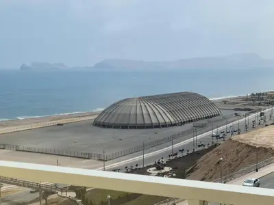 a large building next to the ocean next to a road at DEPARTAMENTO FRENTE ARENa 1 in Lima
