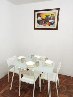 a white table with white chairs and a picture on the wall at Departamento 2 HABITACIONES 1A in Lima