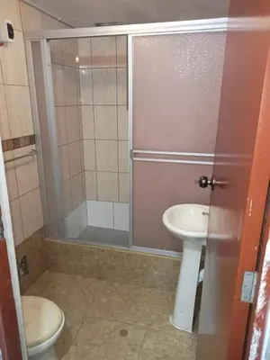 a bathroom with a shower and a toilet and a sink at Departamento 2 HABITACIONES 1A in Lima