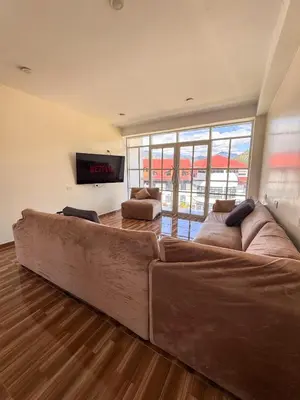 a large brown couch in a living room with a tv at Hotel Krammer en San Ramón, Selva Central in San Ramón