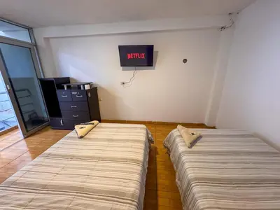 two beds in a room with a sign on the wall at Hotel Krammer en San Ramón, Selva Central in San Ramón