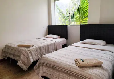 a room with two beds and a window at Hotel Krammer en San Ramón, Selva Central in San Ramón